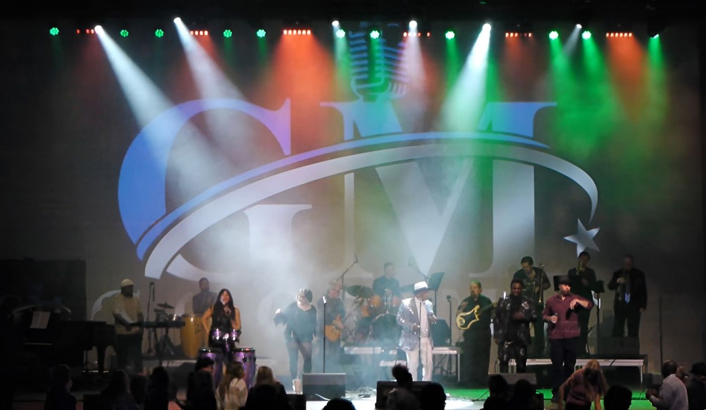 Good Mix Music performing live on stage under colorful lights with the GM logo